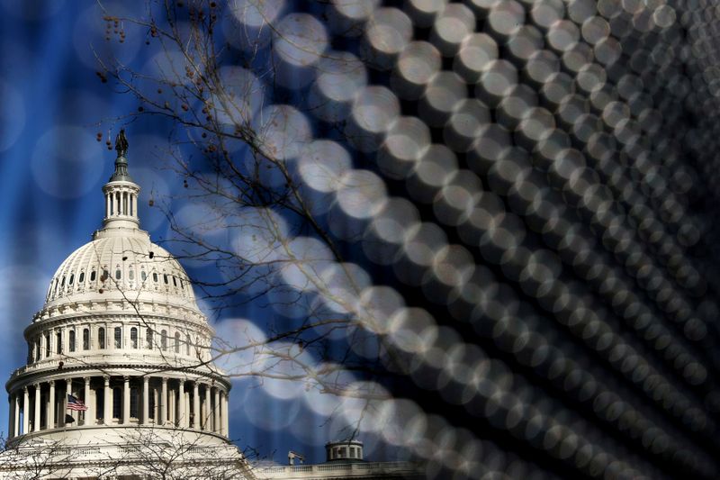 &copy; Reuters. FILE PHOTO: Light catches the security fence around the U.S. Capitol, erected in the wake of the January 6th attack but now scheduled to start being removed, in Washington