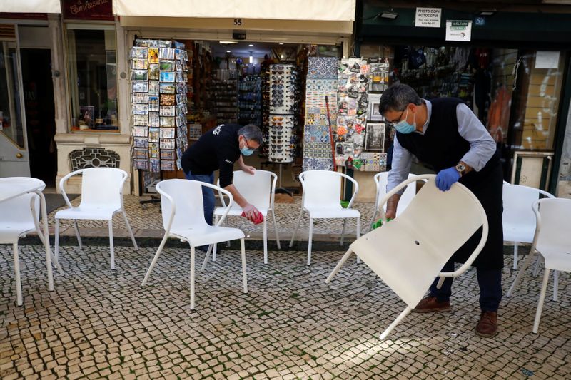 &copy; Reuters. Trabajadores limpiando sillas para abrir la terraza de un restaurante en el primer día de la reapertura tras el cierre del país, en medio de la pandemia de la enfermedad del coronavirus (COVID-19), en Lisboa