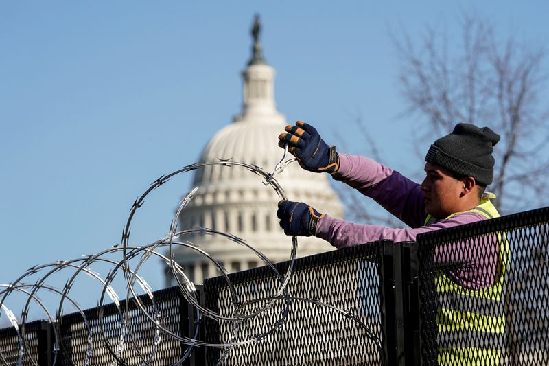 © Reuters. Funcionário remove arame de cerca no entorno do Capitólio, em Washington