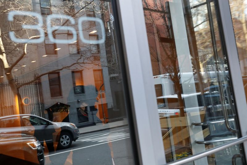 &copy; Reuters. A woman leaves 360 West 43rd street as security and a doorman stand inside the building, where a man has now been arrested and charged with assaulting a 65-year-old Asian woman in a hate crime, in New York City