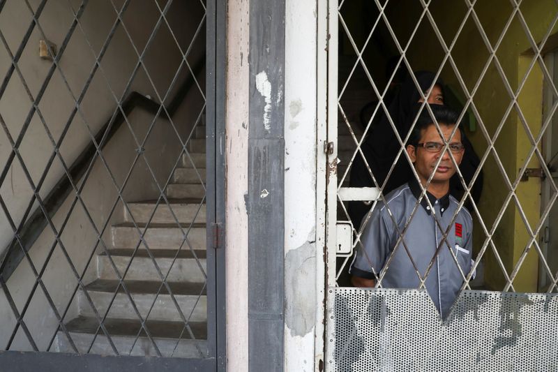 &copy; Reuters. Rohingya refugee and activist Zafar Ahmad Abdul Ghani and his wife look out from their home in Kuala Lumpur