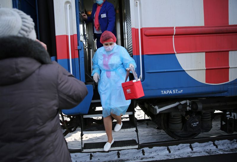 &copy; Reuters. A medical worker carries a bag containing doses of COVID-19 vaccine as she leaves a carriage of a medical train in Tulun