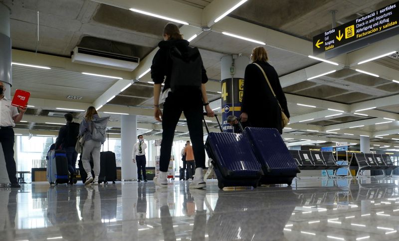 &copy; Reuters. Pasajeros con mascarilla llegan al aeropuerto de Son Sant Joan en Palma de Mallorca, antes de Semana Santa