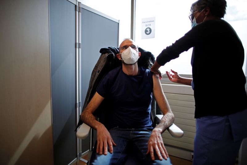 &copy; Reuters. FOTO DE ARCHIVO: Una trabajadora sanitaria administra a un hombre una dosis de la vacuna de Pfizer y BioNTech contra la COVID-19 en un hospital de Melun