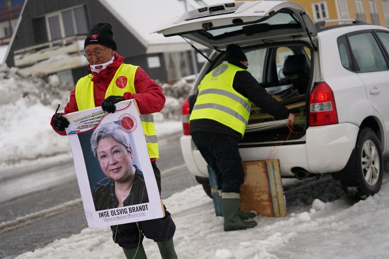 &copy; Reuters. Un voluntario del partido Inuit Ataqatigiit sostiene un cartel electroal en Nuuk