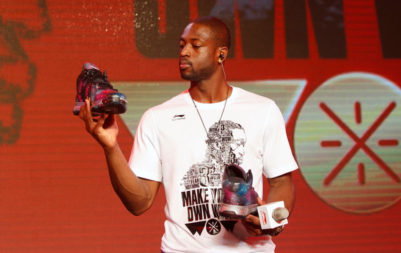 &copy; Reuters. NBA Miami Heat&apos;s Wade looks at a pair of Li Ning&apos;s Way of Wade sneakers designed by a fan during a promotional event for the company in Beijing