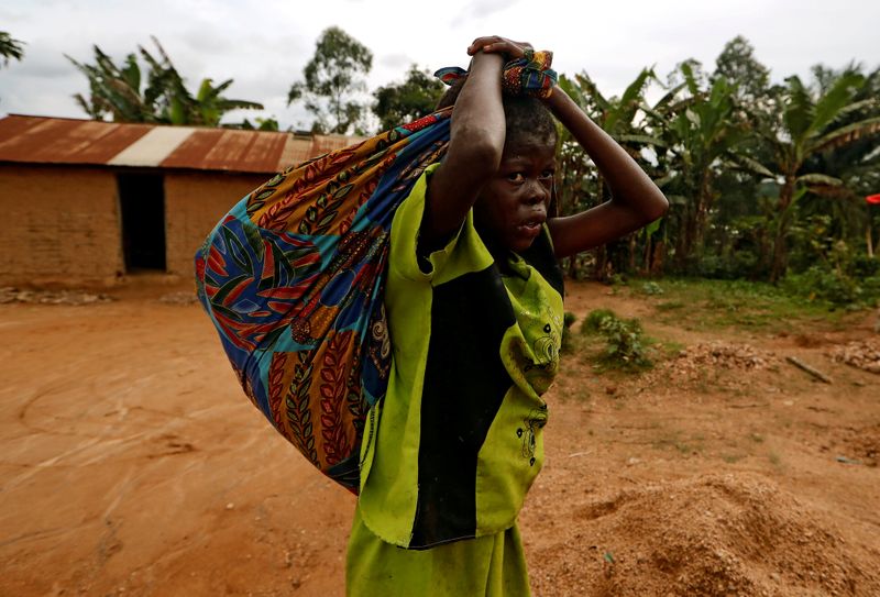 &copy; Reuters. FILE PHOTO: A girl carries cassava leaves on her back as she walks back home from the field in Beni