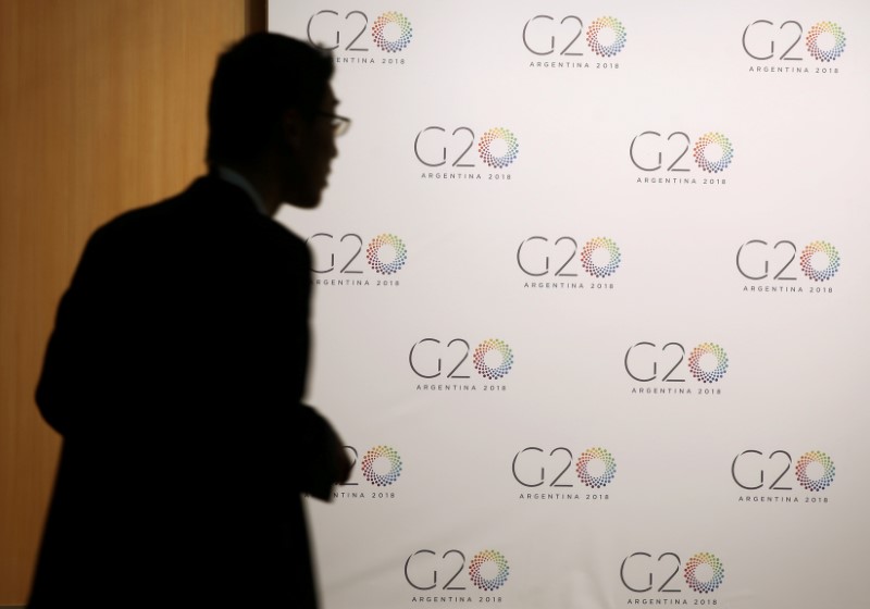 &copy; Reuters. Homem ao lado de um quadro com o logotipo da reunião de ministros das Finanças do G20