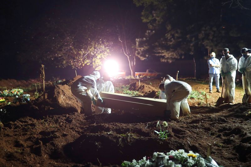 &copy; Reuters. Imagen de archivo. Sepultureros con trajes protectores llevan un ataúd de un hombre de 32 años que murió por la enfermedad del coronavirus, cementerio de Vila Formosa en Sao Paulo