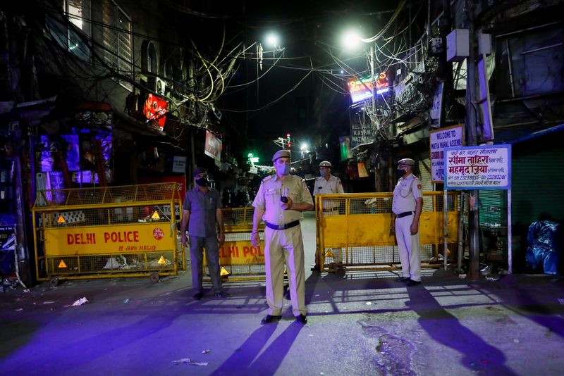&copy; Reuters. Agentes de policía hacen guardia en una calle desierta durante un toque de queda para limitar la propagación del coronavirus (COVID-19), en Nueva Delhi
