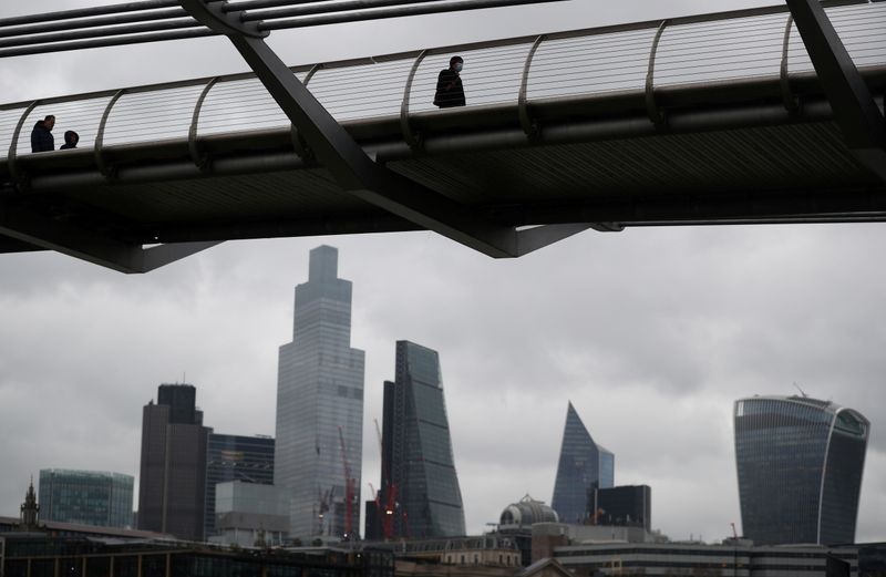 &copy; Reuters. FILE PHOTO: People walk across Millennium Bridge with the City of London financial district seen behind, amid the coronavirus disease (COVID-19) pandemic, in London