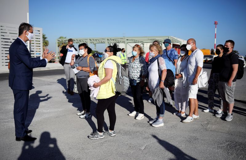 &copy; Reuters. FILE PHOTO: Greek Tourism Minister Harry Theoharis welcomes passengers from Germany, who were frontline workers during the coronavirus disease (COVID-19) outbreak, after landing on a TUI Airways flight at Kos International Airport on the island of Kos