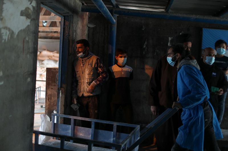 © Reuters. Palestinians receive food supplies at UNRWA distribution center in Gaza