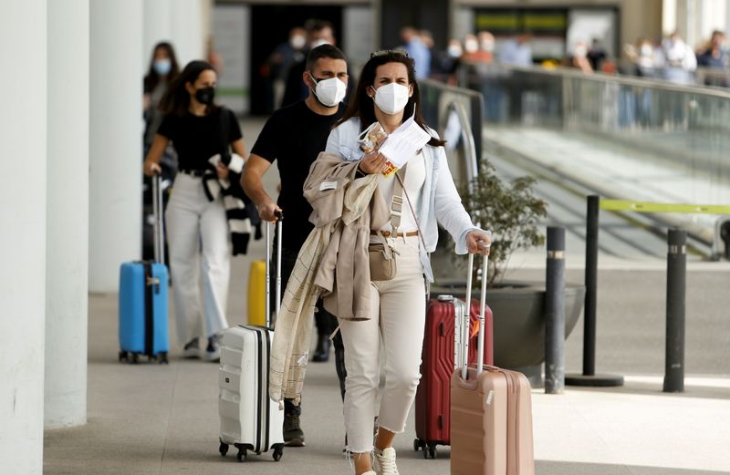 &copy; Reuters. FOTO DE ARCHIVO: Varios pasajeros con mascarillas en el área de llegadas del aeropuerto de Son Sant Joan de Palma de Mallorca