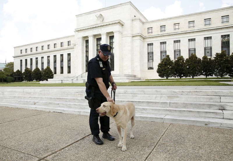 &copy; Reuters. FOTO DE ARCHIVO-Un policía patrulla con su perro Brodie frente a la Reserva Federal en Washington.