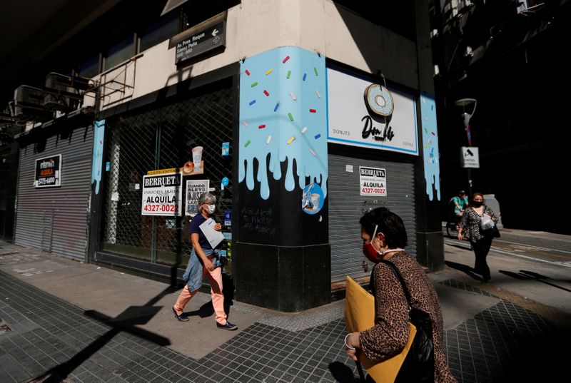 &copy; Reuters. Pedestrians walk past out-of-business stores which display &quot;For rent&quot; signs, near the Buenos Aires&apos; Obelisk