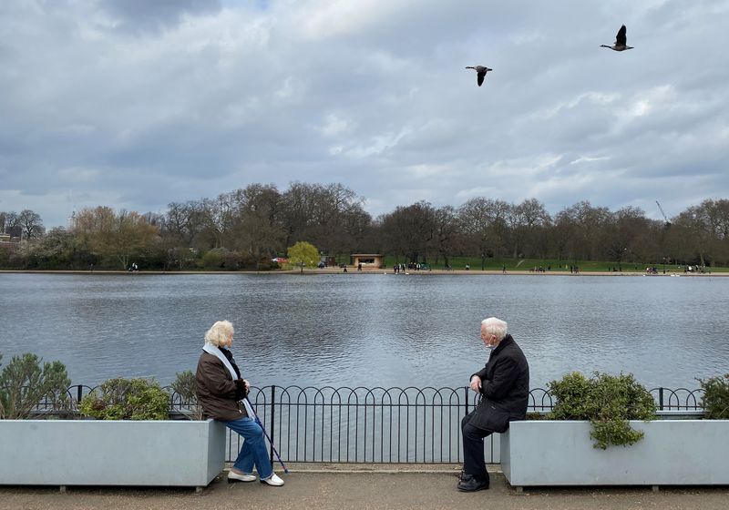 &copy; Reuters. FILE PHOTO: Two people are seen socially distancing as they chat together in Hyde Park, London