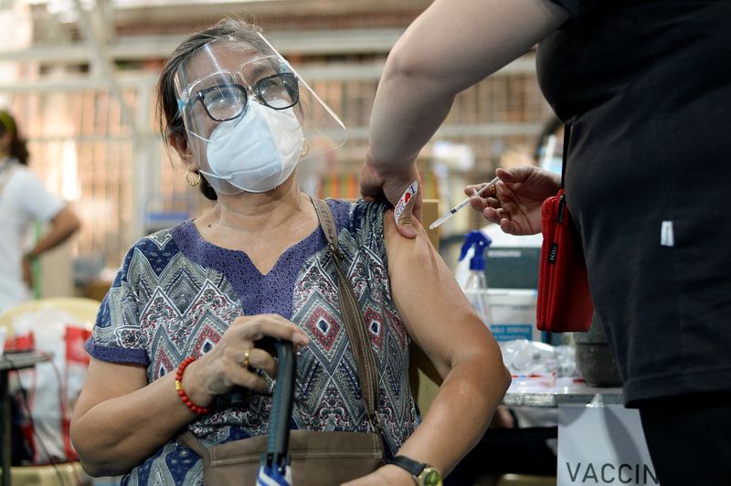 &copy; Reuters. FOTO DE ARCHIVO: Una mujer recibe su primera dosis de la vacuna de AstraZeneca contra la COVID-19 en Manila