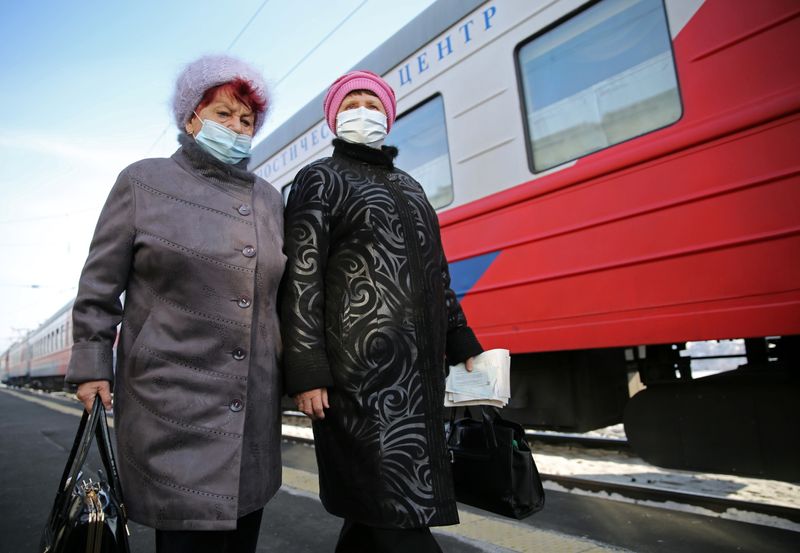 &copy; Reuters. Women walk next to the Academician Fyodor Uglov medical train in Tulun