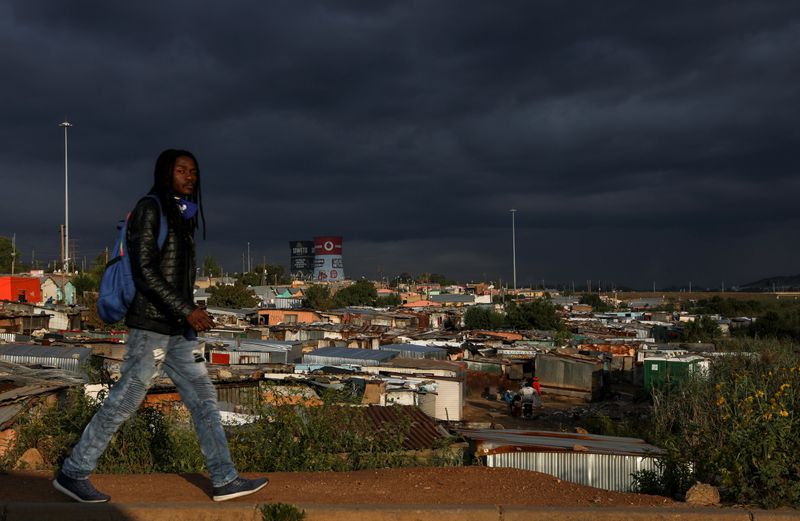 &copy; Reuters. Homem passa por um assentamento informal enquanto restrições à mobilidade são amenizadas no Soweto