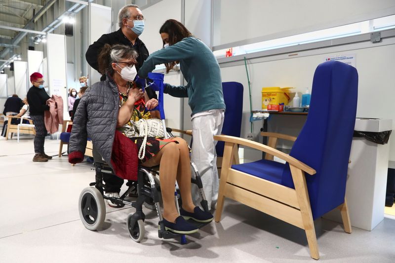 &copy; Reuters. Foto de archivo de una mujer en silla de ruedas recibiendo la vacuna de AstraZeneca contra el COVID-19 en el hospital Enfermera Isabel Zendal de Madrid