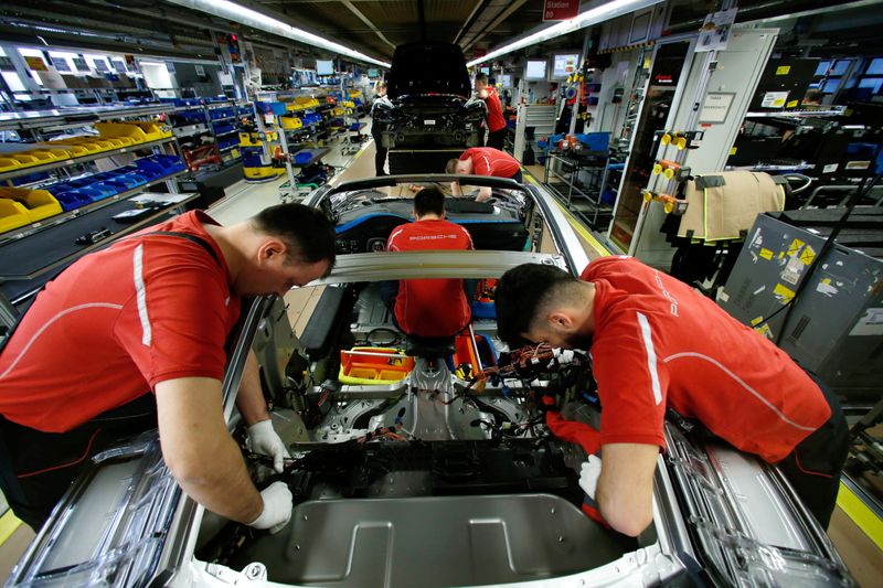 &copy; Reuters. FOTO DE ARCHIVO: Empleados del fabricante alemán de automóviles Porsche trabajan en un Porsche 911 en la fábrica de Porsche en Stuttgart-Zuffenhausen, Alemania, 19 de febrero de 2019