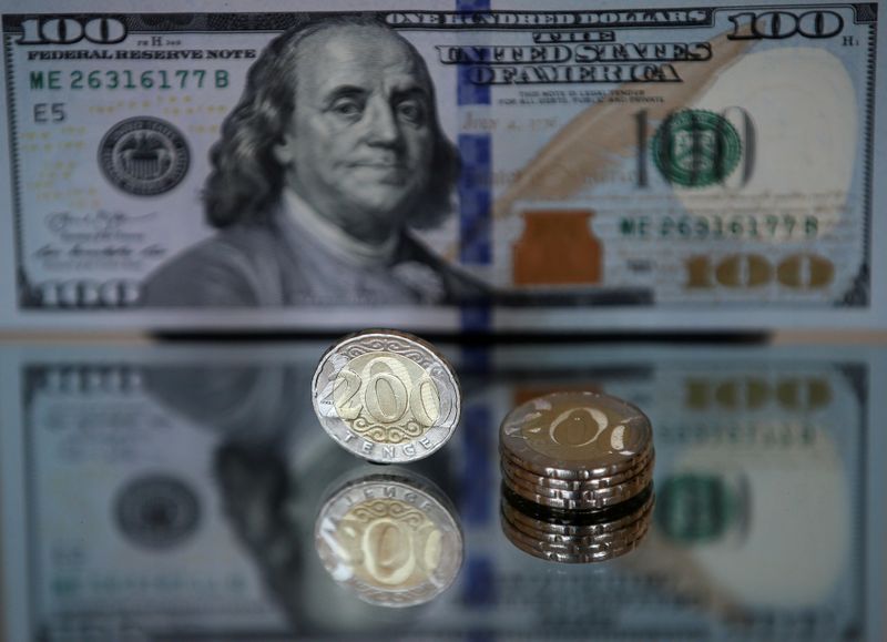 &copy; Reuters. Kazakh 200 tenge coins are pictured in front of a U.S. 100 dollar banknote in this illustration
