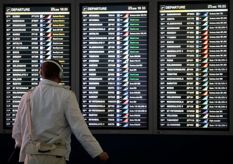 © Reuters. A man looks at a flight information board at the departure zone of Vnukovo International Airport in Moscow