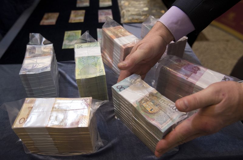 &copy; Reuters. File photo of bank employee holding new banknotes during news conference in Minsk