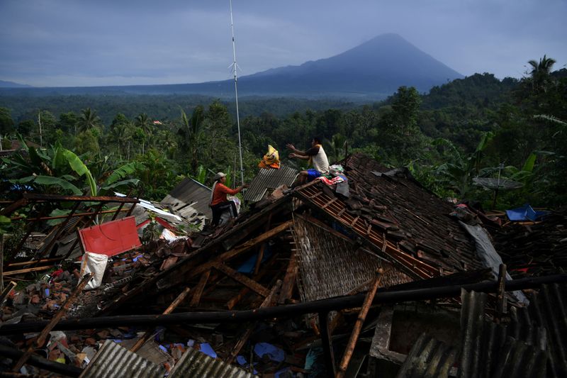 &copy; Reuters. People salvage their belongings from a house damaged by an earthquake in Lumajang