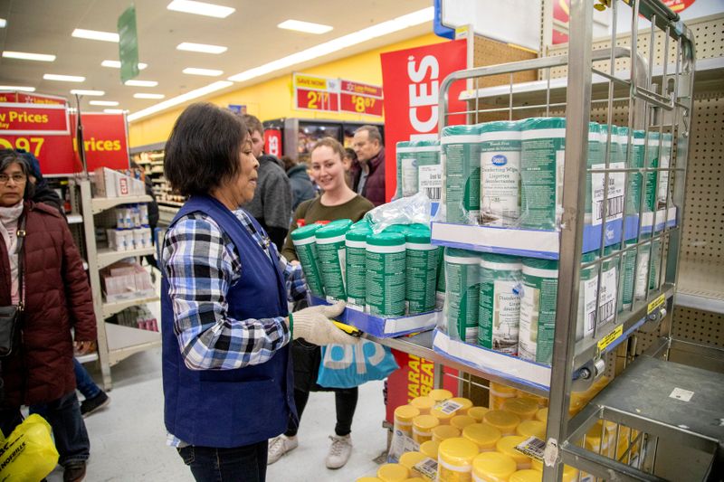 © Reuters. FILE PHOTO: People gather supplies at a grocery store amid coronavirus fears spreading in Toronto