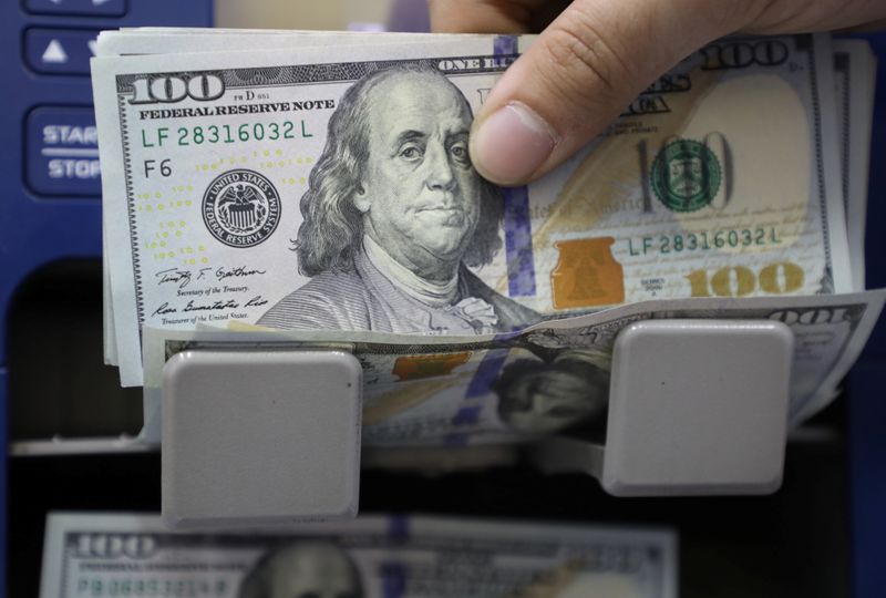 &copy; Reuters. Un uomo conta banconote da 100 dollari a Beirut, in Libano
