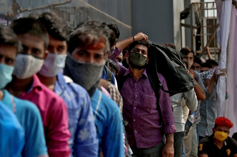 &copy; Reuters. Pessos fazem fila para entrar em estação ferroviária em Mumbai, na Índia, em meio à pandemia de Covid-19
