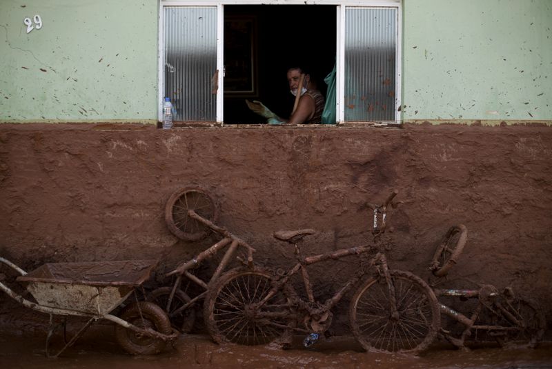 &copy; Reuters. FILE PHOTO: A man works on the cleaning of a house flooded with mud after a dam, owned by Vale SA and BHP Billiton Ltd burst, in Barra Longa