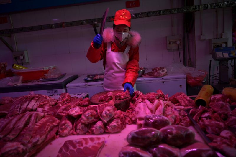 &copy; Reuters. Trabalhador corta pedaços de carne suína em mercado em Pequin, na China