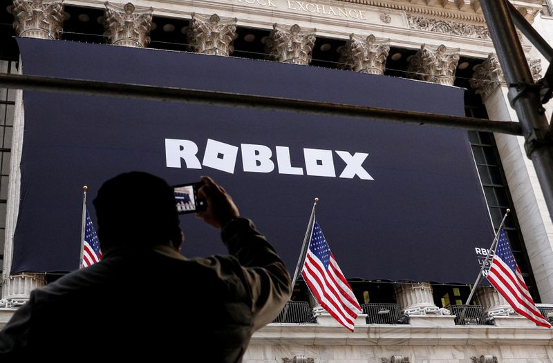 &copy; Reuters. FILE PHOTO: A man photographs a Roblox banner displayed, to celebrate the company&apos;s IPO at the NYSE is seen in New York
