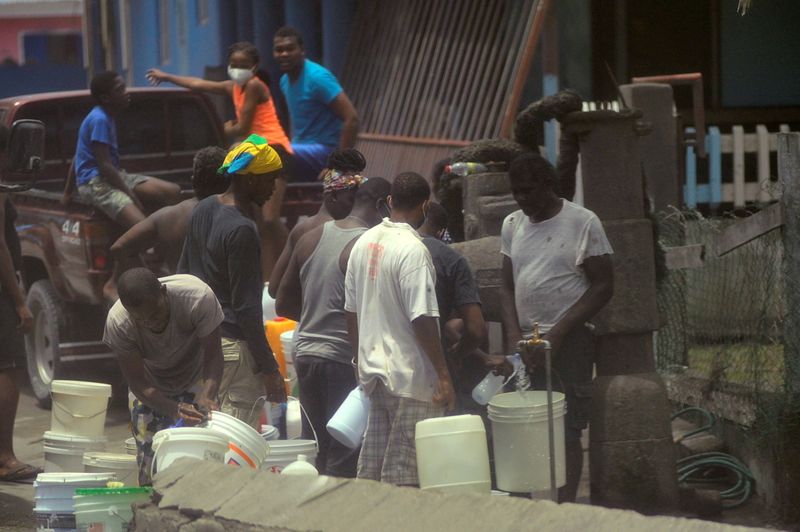 &copy; Reuters. Local residents fill containers of water after a series of eruptions from La Soufriere volcano