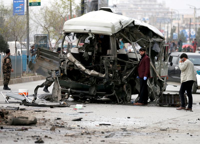 &copy; Reuters. FILE PHOTO: Afghan officials inspect a damaged minibus after a blast in Kabul