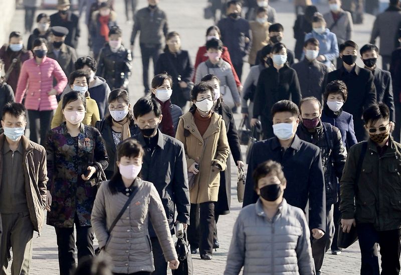 &copy; Reuters. FILE PHOTO: People wearing protective face masks commute amid concerns over the new coronavirus disease in Pyongyang, North Korea