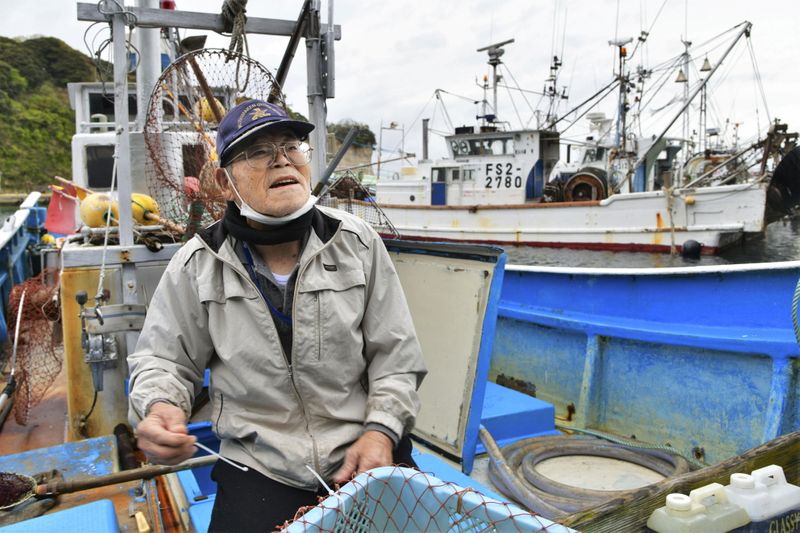 &copy; Reuters. Un pescador en su barco tras regresar de una jornada de pesca en el puerto de Iwaki