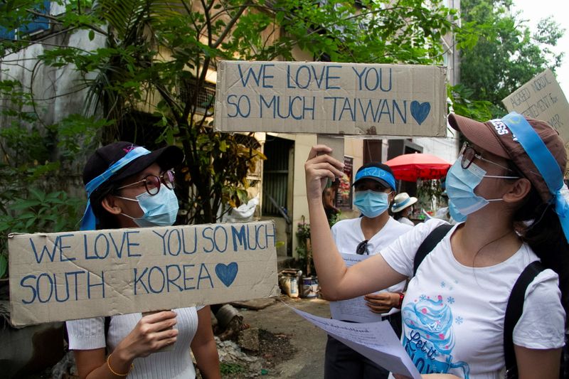 &copy; Reuters. FILE PHOTO: Demonstrators carry placards as they march during a protest against military coup, in Yangon