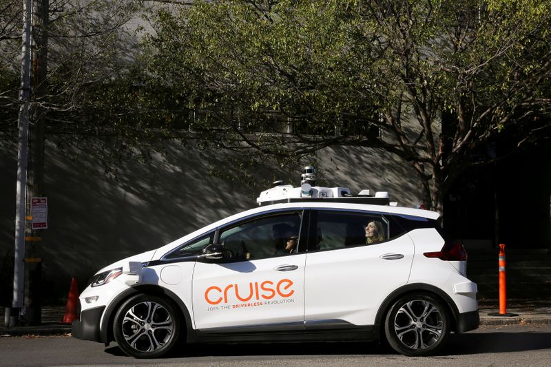 &copy; Reuters. FILE PHOTO: A woman smiles in the back seat of a self-driving Chevy Bolt EV car during a media event by Cruise, GM’s autonomous car unit,  in San Francisco