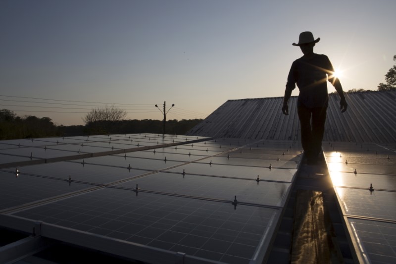 &copy; Reuters. Homem checa painéis de energia solar em Vila Nova do Amanã (AM)