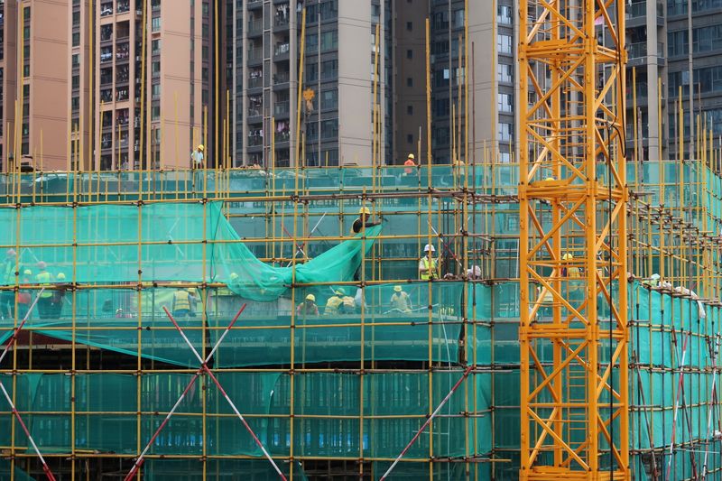 © Reuters. FILE PHOTO: Workers are seen on scaffoldings of a construction site near residential buildings in Shenzhen, following the novel coronavirus disease (COVID-19) outbreak