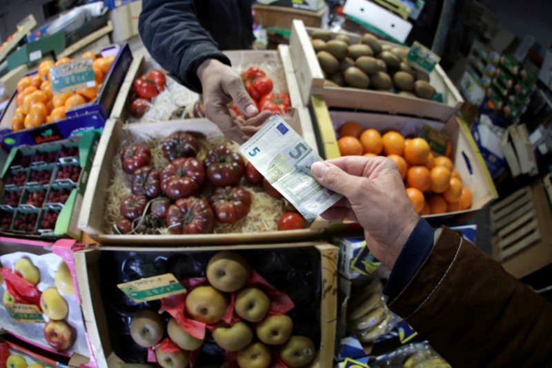 &copy; Reuters. FOTO DE ARCHIVO: Un comprador paga con un billete de 5 euros en un mercado de Niza