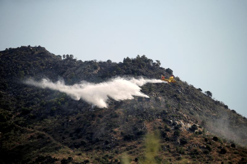 &copy; Reuters. Un avión lanza agua en la lucha contra un incendio forestal en Robledo de Chavela, cerca de Madrid