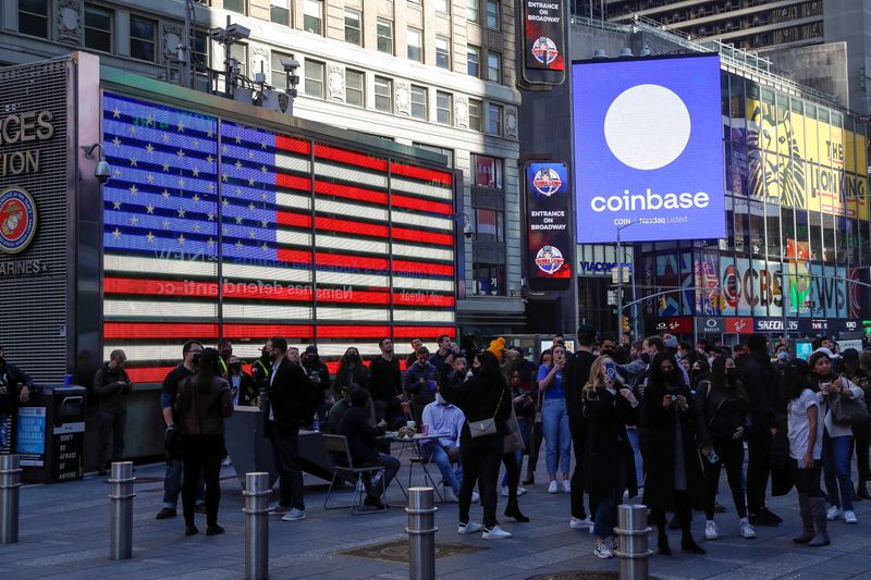 © Reuters. FILE PHOTO: Employees of Coinbase Global Inc, the biggest U.S. cryptocurrency exchange, watch as their listing is displayed on the Nasdaq MarketSite jumbotron at Times Square in New York