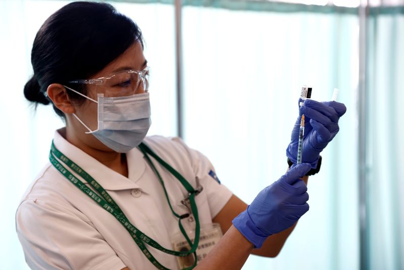 &copy; Reuters. A medical worker fills a syringe with a dose of the Pfizer-BioNTech coronavirus disease (COVID-19) vaccine as Japan launches its inoculation campaign, at Tokyo Medical Center in Tokyo