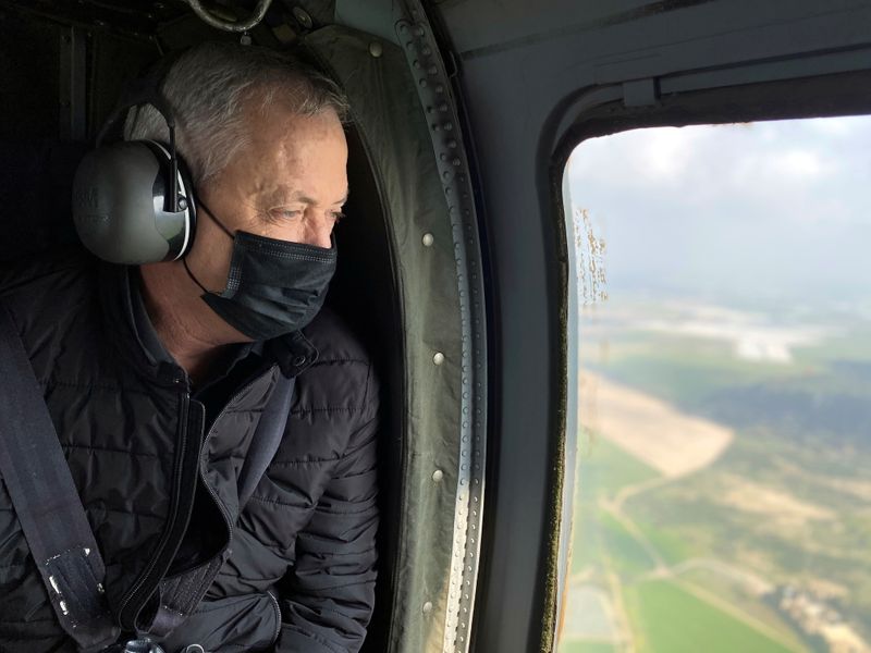 &copy; Reuters. FILE PHOTO: Israeli Defence Minister Benny Gantz wears a face mask as he looks out from the window of a helicopter during a tour of the Gaza border area in southern Israel