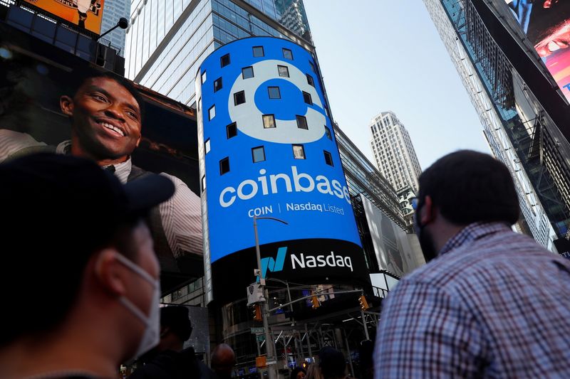 &copy; Reuters. FILE PHOTO: People watch as the logo for Coinbase Global Inc, the biggest U.S. cryptocurrency exchange, is displayed on the Nasdaq MarketSite jumbotron at Times Square in New York